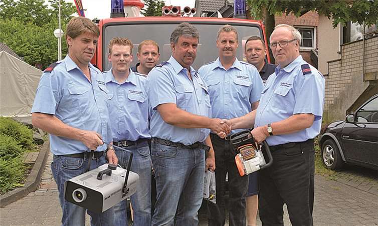 Bernhard Schneider übergibt einen Vernebler und eine Motorkettensäge an Wilfried Schmahl. AB