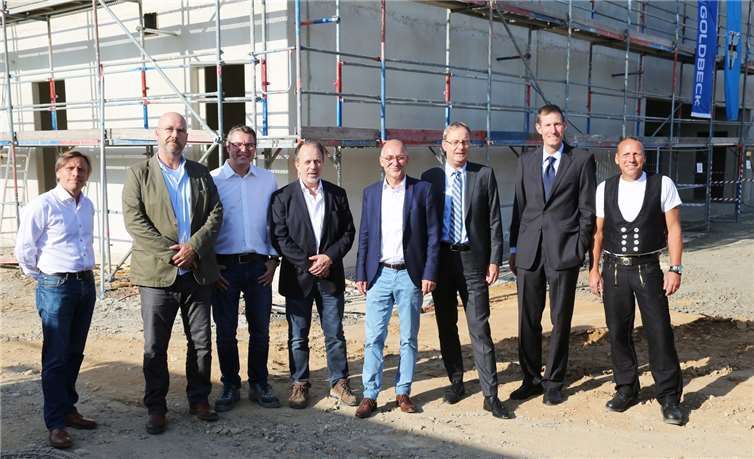 Bert Spilles freut sich mit Unternehmern, Planern und Mitarbeitern über die Fertigstellung des Rohbaus. -StF-
