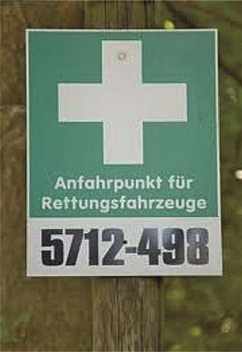 Beschilderung eines Rettungspunkts: Vorangestellt die 4-stellige Rettungskartennummer, mit Bindestrich abgesetzt die 3-stellige Rettungspunktnummer.
