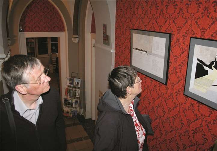 Besucher betrachten im Treppenhaus Arbeiten von Kurt Roessler.