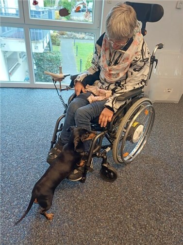 Besucherin der Tagesförderstätte der Lebenshilfe Mayen mit Dackeldame Hildegard.  Foto: Lisa Hartmann