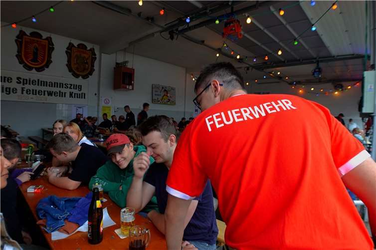 Besucherinnen und Besucher sowie Feuerwehrleute feiern gemeinsam bei ausgelassener Atmosphäre. Fotos: MBE