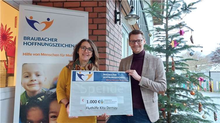 Bettina Bäcker freut sich über die finanzielle Unterstützung der Braubacher Hoffnungszeichen für den Wiederaufbau des Kindergartens St. Johannes Apostel in ihrer Heimatgemeinde Dernau an der Ahr. Markus Fischer vom Braubacher Wohltätigkeitsverein übergab ihr symbolisch den Spendenscheck über 1.000 Euro.  Foto: Braubacher Hoffnungszeichen e. V.