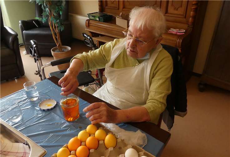 Bewohnerin Hedwig Thelen färbt mit vollem Engagement und sehr konzentriert die Ostereier. Foto: privat