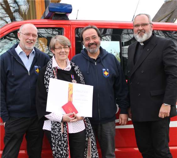 Bezirksreferent Stephan Geller, Pastoralreferent Rainer Dämgen und Dekan Dr. Axel Wengenroth freuen sich mit Pfarrerin Ulrike Braun-Steinebach über die Auszeichneung der Feuerwehr (v. li.).