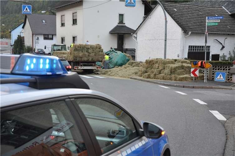 Traktor mit Heuballen kippt um 