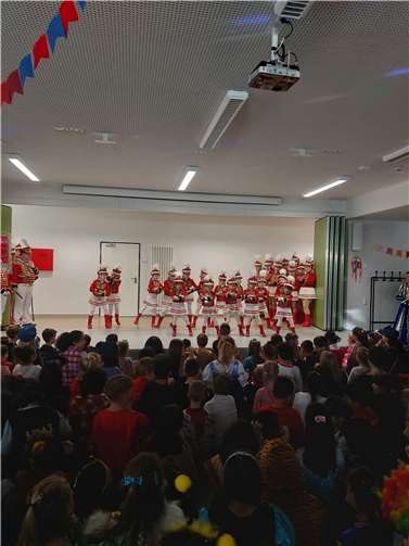 Karnevalstruppen besuchen die Kinder in der Aula 