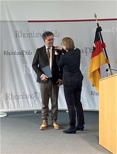 Bildungsministerin Hubig steckt Herrn Störmer die Verdienstmedaille an.  Foto: Ministerium für Bildung