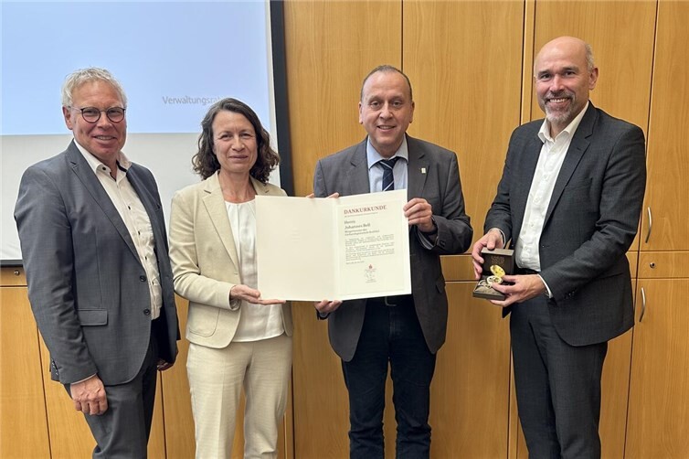 Bildunterschrift: Landrätin und Verwaltungsratsvorsitzende Cornelia Weigand gratuliert Johannes Bell zusammen mit Guido Mombauer und Achim Gemein zur Auszeichnung.