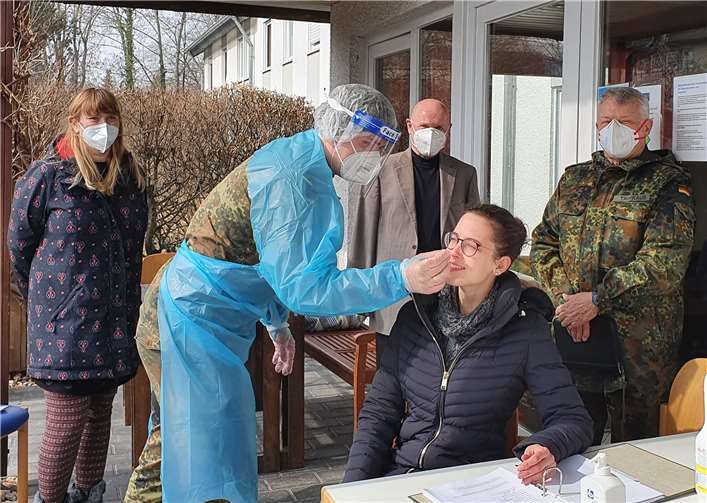 Bildunterschrift: Oberleutnant Christian Nickel gemeinsam mit Oberstleutnant Harald Trinkaus (rechts), Ulrich van Bebber, Vorstandsvorsitzender der Lebenshilfe Ahrweiler und Vorstandsmitglied Nicole Falkenstein-Seifen (links) bei der PoC-Testung von Verena Groß, Mitarbeiterin der Lebenshilfe.Foto: privat