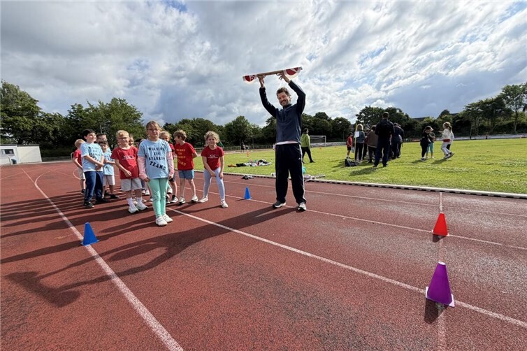 Bildunterschrift:„Wir sind ein starkes Team“: Kurz vor dem Start des 30-Meter-Sprints zeigen die Schülerinnen und Schüler der KGS Meckenheim Teamgeist und Vorfreude auf die Wettkämpfe in Sprint, Ausdauer, Zonenweitwurf und Zonenweitsprung.