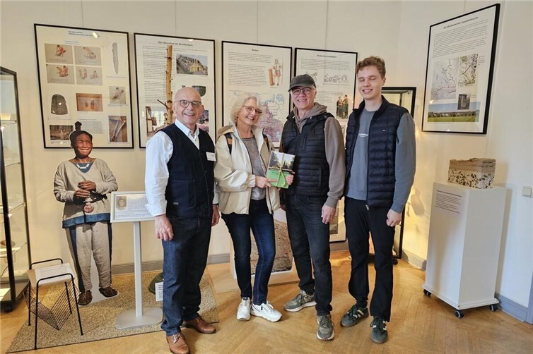 Birgit Lenkeit aus Röttgen freute sich über ein Buchpräsent, das ihr Dieter Ohm (im Bild links), Vorsitzender des Vereins Meckenheimer Stadtmuseum und Kulturforum, überreichte. Ihr Ehemann Thomas Lenkeit und Sohn Benjamin waren mit ins Museum gekommen.