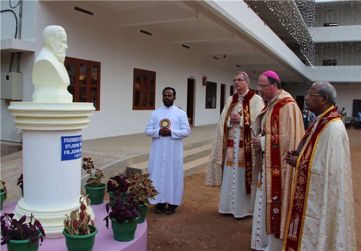 Bischof Dr. Ackermann und Weihbischof Peters bei einer Schuleinweihung in Indien vor einer Haw-Statue.