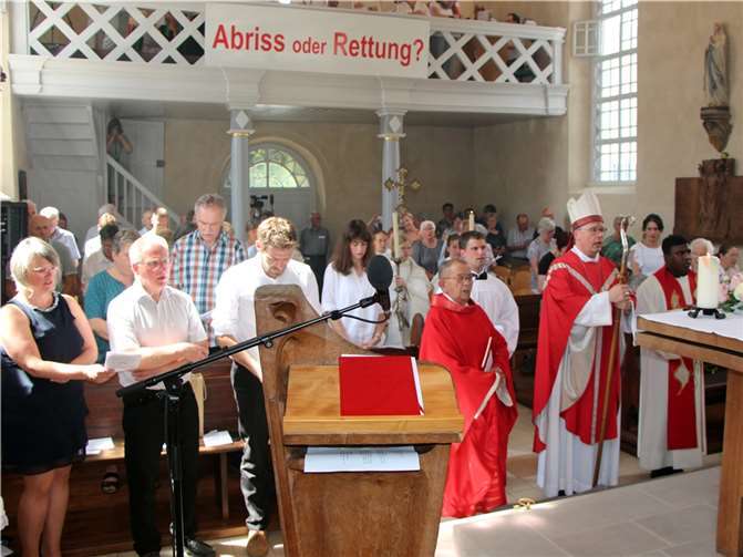Bischof Dr. Stephan Ackermann feierte mit der Gemeinde die Wiedereröffnung der St. Matthias-Kapelle in Leimbach. Der Banner mit der Aufschrift ‚Abriss oder Rettung?‘ ist nun Geschichte, ebenso wie der Förderverein, hier vertreten durch Nina Becker (vorne links) und Norbert Löhr (vorne Zweiter von links).  Foto: Brigitte Bettscheider