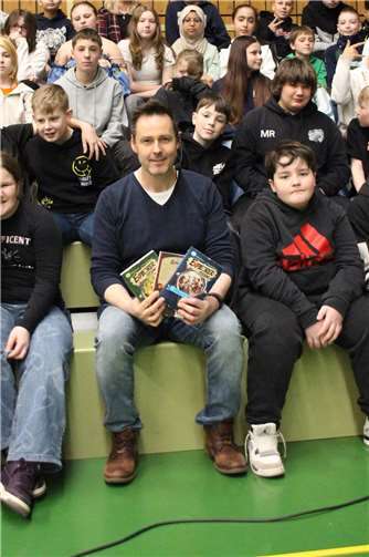 Björn Berenz regte mit seiner fröhlichen Buchvorstellung die jungen Zuhörer zum Miträtseln an.  Quelle: Realschule plus und FOS Untermosel
