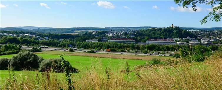 Blick von der Nelkenstraße/Beulköpfchen: Rechts Schloss Montabaur und das FOC mit seinen überdimensionierten Werbetafeln, links das Wohngebiet Kesselwiese mit dem davor liegenden Grünzug und dem zu erhaltenden Biotopkomplex.  Foto: Harry Neumann