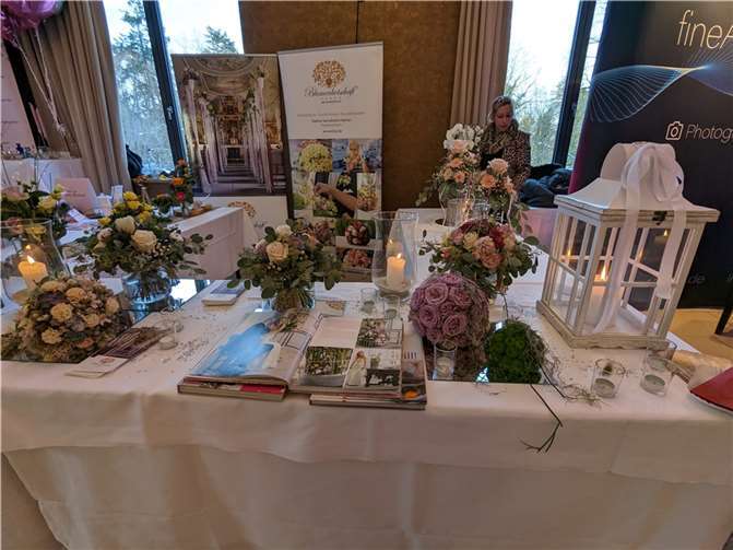 Blumenbotschaft „Vier Jahreszeiten“ zeigte Brautsträuße und Tischdekorationen.