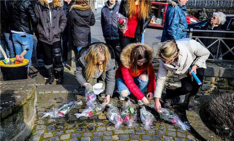 Blutrote Rosen legten die Schüler und Schülerinnen auf die Steine, die an den zuletzt „selbstgewählten“ Wohnort der Juden in das Pflaster eingebarbeitet wurden. EP