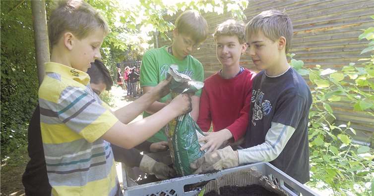 Boeselager-Realschüler bauen Hochbeete aus stapelbaren Plastikkisten und befüllen diese mit Stöcken, Kompost und fruchtbarer Erde.privat