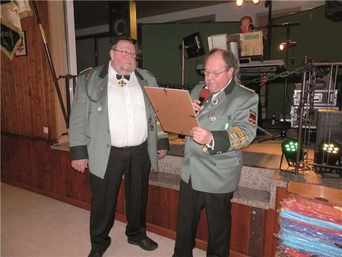 Brudermeister Rainer Doll überreicht Rudi Lück die Urkunde zum Ehrenbrudermeister.