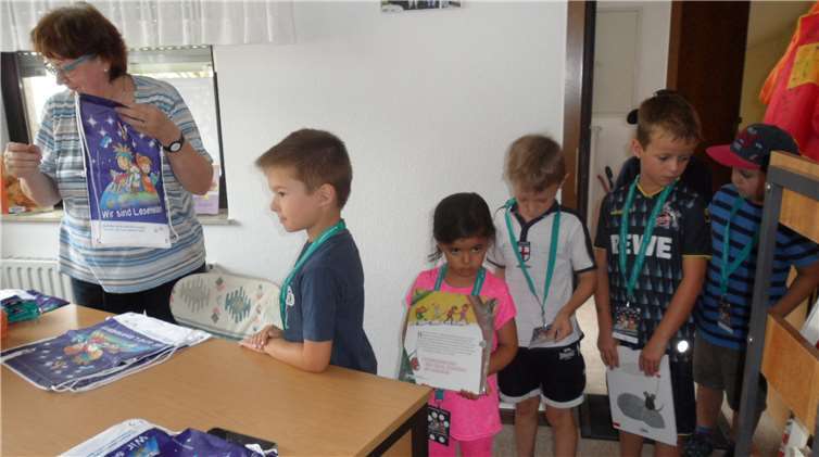 Bücher werden eingetragen und in dieneuen Rucksäcke verpackt.