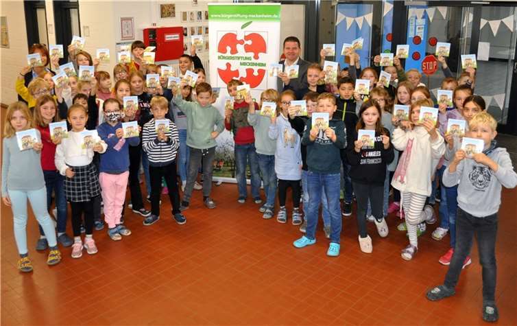 Bücherübergabe in der Katholischen Grundschule Merl mit dem Vorsitzenden der Bürgerstiftung, Bürgermeister Holger Jung, der kommissarischen Schulleiterin Birgit Goldmann und den Schülerinnen und Schülern der dritten und vierten Jahrgänge. Foto: Bürgerstiftung Meckenheim