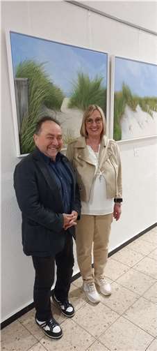 Bürgermeister Alfred Schomisch (li.) mit Sabina Wölwer im Foyer der Verbandsgemeindeverwaltung Vordereifel bei der Vernissage zur Ausstellung „Meerblick - Dünen & Strand Sylt.