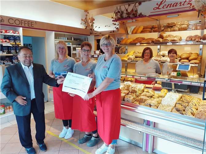 Shoppen für den guten Zweck: 7.000 Euro für Hilfe von Flutgeschädigten Bürgermeister Alfred Schomisch (li.) nimmt den symbolischen Spendenscheck von Elke Lenartz (re. im Bild) in der Filiale der Bäckerei Lenartz in Ettringen in Empfang.