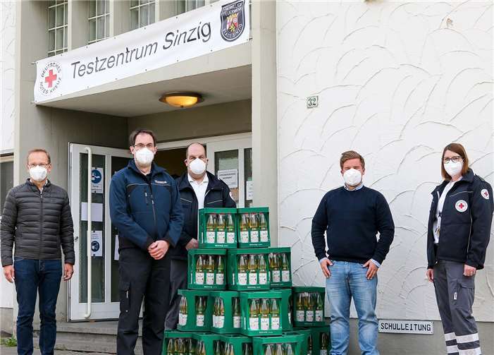 Bürgermeister Andreas Geron, Sinzigs stellvertretender Wehrführer Andreas Trog, Sinzigs DRK-Bereitschaftsleiter Marco Hengsberg, und DRK-Bereitschaftsleiterin Judith Grobelny (v.li.) nahmen von Christopher Menzel vom Sinziger Mineralbrunnen (2. v. re.) 600 Liter des Erfrischungsgetränks „Sinziger Balance“ als Spende für das Schnelltestzentrum in Empfang. Foto: Thorsten Trütgen