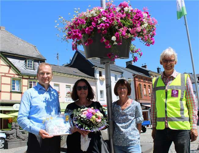 Bürgermeister Andreas Geron bedankte sich bei der Gewinnerin Andrea Schraaf-Wilhelmy mit frischen Blumen und einem Buchgeschenk.Fotos:ROB