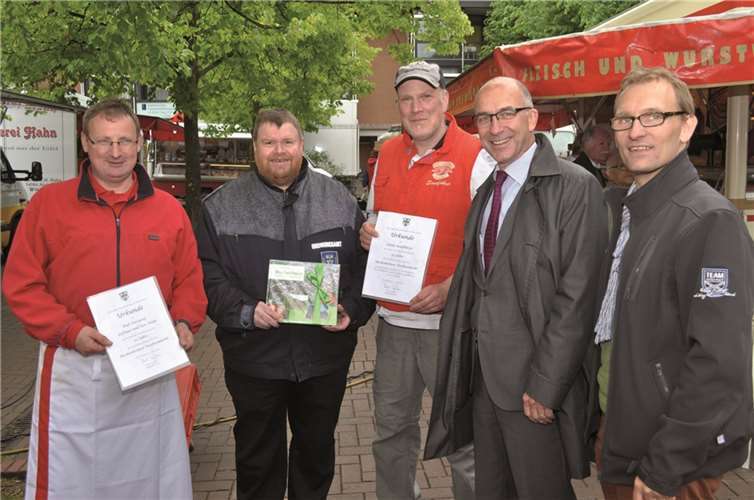 Bürgermeister Bert Spilles (2.v.r.), Marktmeister Jörg Begerow (2.v.l.) und Wirtschaftsförderer Dirk Schwindenhammer (r.) überreichten Ralf Davepon (l.), Inhaber der Firma Huth und Guido Sandführer (m.) eine Urkunde.  Stadt Meckenheim