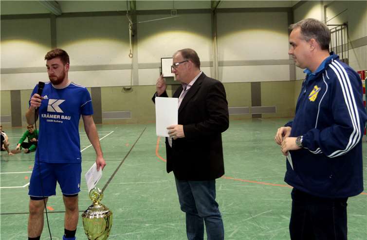 Bürgermeister Guido Nisius (Mitte) und Mike Mönig, Organisator und Vorsitzender der DJK überreichen Urkunde und Geldprämie an den Spielführer der DJK für Platz 2.