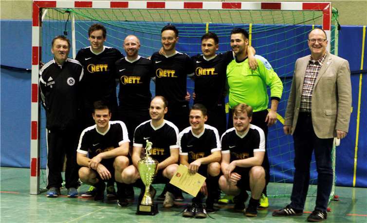 Bürgermeister Guido Nisius (r. ) überreichte den Gewinnern des Hallenturniers der Verbandsgemeinde, der ersten Mannschaft der SG Hocheifel, den begehrten Wanderpokal.