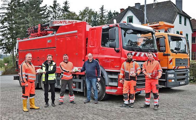 Bürgermeister Guido Nisius und Werkleiter Jürgen Adriany übergeben kleine Abschiedsgeschenke an Teamleiter Jens Franz (Bildmitte) und seine Mannschaft. Foto: Werner Dreschers