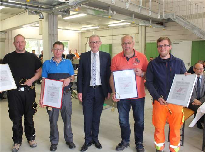 Bürgermeister Guido Orthen übergab den Abteilungsleitern Holz, Farbe, Elektro und Material zur Einweihung des neuen Werkstattgebäudes Urkunden und einen symbolischen goldenen Schlüssel.  DU