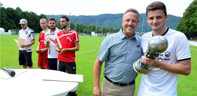 Bürgermeister Hans Werner Breithausen überreichtedem Ellinger Spielführer Kevin Kleinmann den Amtspokal.