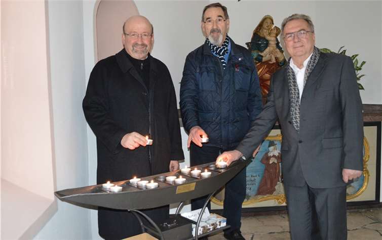 Bürgermeister Herbert Georgi, Harry Sander und Frank Krajewski (von links) am neuen Kerzenständer in der Hochwassernotkapelle.AB