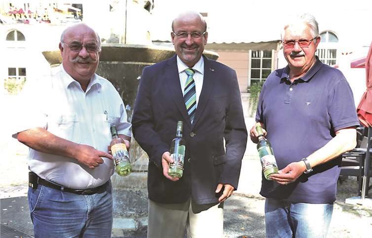 Bürgermeister Herbert Georgi nahm hoch erfreut die Weinflaschen der Weinbaugemeinschaft aus den Händen von Eduard Krahe und Martin Tillmann entgegen. StF