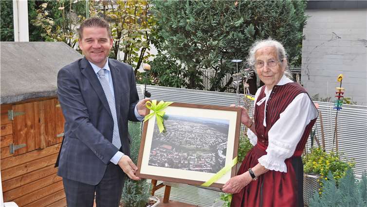 Bürgermeister Holger Jung gratuliert Meckenheims Ehrenbürgerin Erika Meyer zu Drewer zum 90. Geburtstag und überreicht eine Luftbildaufnahme der Apfelstadt.Quelle: Stadt Meckenheim