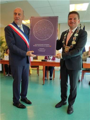 Bürgermeister Holger Jung (re.) überreicht seinem französischen Amtskollegen Franck Vernin ein Bild, das den Sternenhimmel über Meckenheim am Abend der Städtepartnerschaft-Begründung zeigt. Foto: Bürgerverein Meckenheim