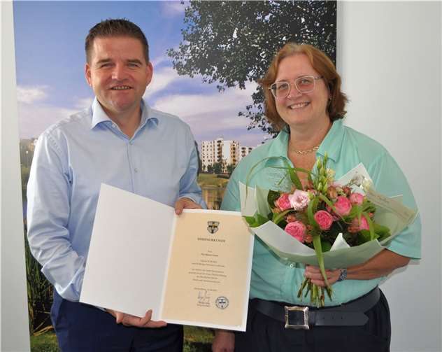 Bürgermeister Holger Jung überreicht Pia-Maria Gietz die Ehrenurkunde und gratuliert ihr herzlich zum Dienstjubiläum. Foto: Stadt Meckenheim