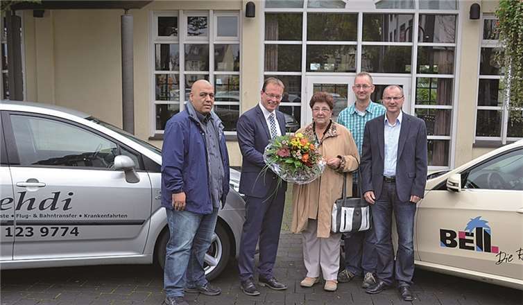 Bürgermeister Jörg Lempertz (2.v.l.) und Seniorenbeauftragter Christian Gelhard (2.v.r.) überreicht Marlies Ammel-Welsch (m.) einen Blumenstrauß. Sie ist der 1.000. Fahrgast des Seniorentaxis der VG Mendig. privat