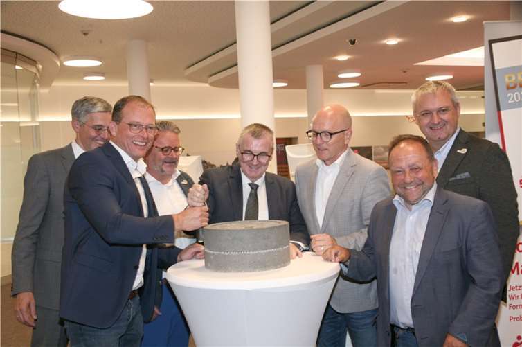 Bürgermeister Jörg Lempertz (l.) und Landrat Dr. Alexander Saftig „eröffnen“ die Ausstellung begeistert, indem sie den Mühlstein „ins Rollen“ bringen.