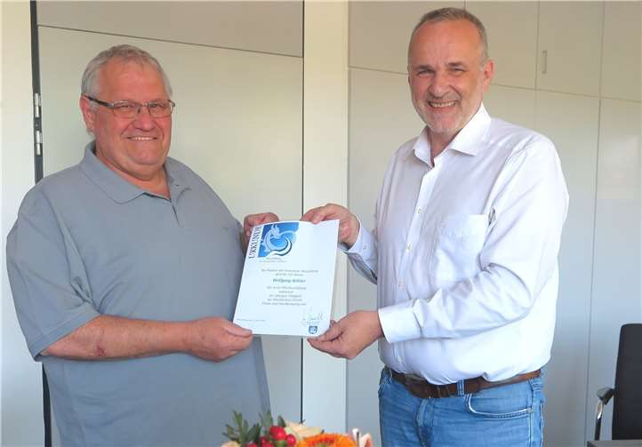 Bürgermeister Jörg Schmidt (re.) dankt Wolfgang Köhler (beide fürs Fotos kurz ohne Maske) für 40 Jahre im Dienst der Gemeinde Wachtberg. Foto: Gemeinde Wachtberg/mm