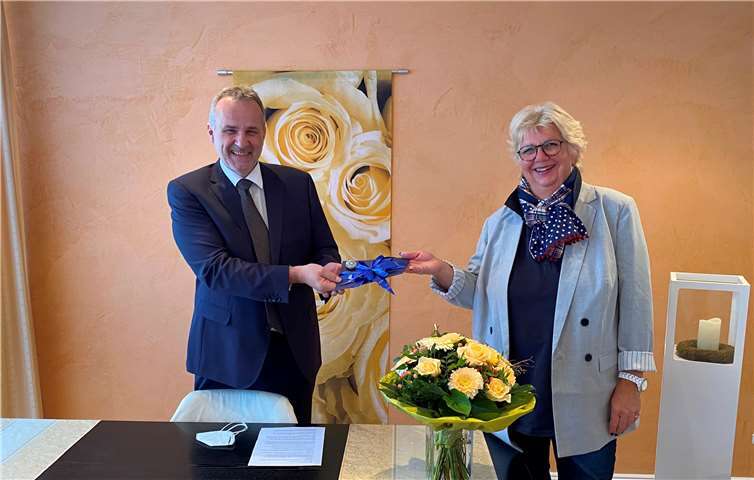 Bürgermeister Jörg Schmidt verabschiedet Sabine Heinen (fürs Foto beide kurz ohne Maske). Foto: Gemeinde Wachtberg/mf