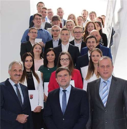 Bürgermeister Johannes Bell (Brohltal), Prüfungsausschussvorsitzender Ralf Pastoors (Neuwied) und Wolfgang Konder von der ADD Trier (vorne v.r.) mit den 23 Verwaltungsfachangestellten. Stadt Neuwied