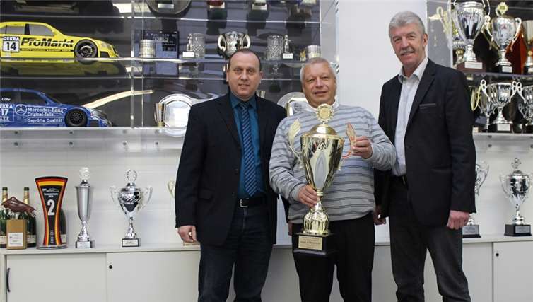 Bürgermeister Johannes Bell (l.) und Ortsbürgermeister Rolf Hans (r.) gratulieren Peter Zakowski zum Gewinn des ADAC GT Masters 2015. privat