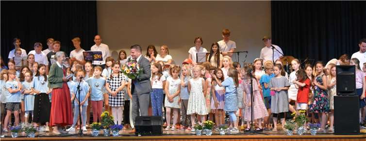 Bürgermeister Jung bedankt sich bei Frau Meyer zu Drewer, im Hintergrund die Chöre und die Mitglieder der Band.