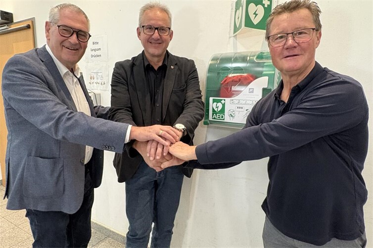 Bürgermeister Matthias Renschler (Mitte) bei der Übergabe der AED-Defibrillatoren mit dem Ersten Beigeordneten Peter Diewald (links) und Ortsvorsteher Richard Lindner