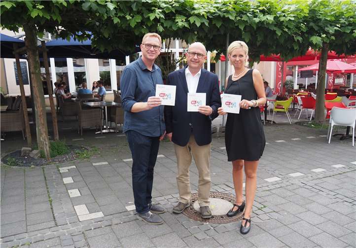 Bürgermeister Michael Kessler freut sich mit Werner Prümm und Celina Klingenberg von der Wirtschaftsförderung über den WLAN-Hotspot am Kirchplatz.privat